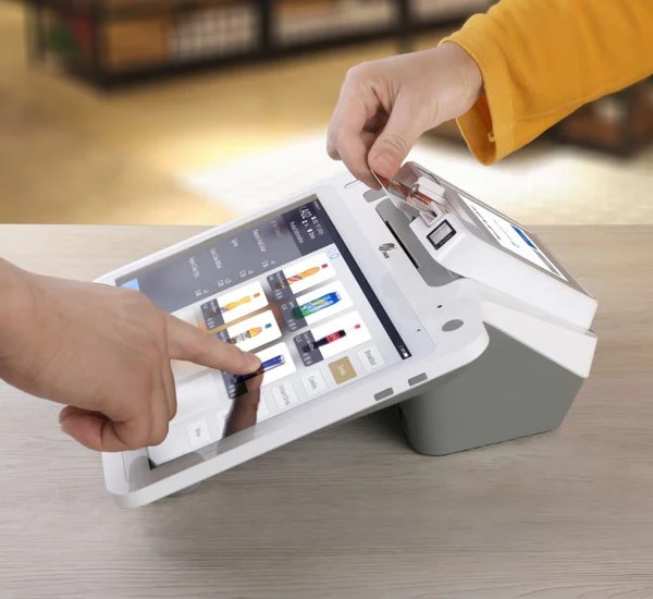 PAX E700 countertop POS with touchscreen at checkout