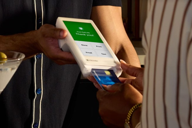 Server using a Clover Flex handheld device for a restaurant payment